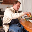 Man choosing fruit from bowl on table